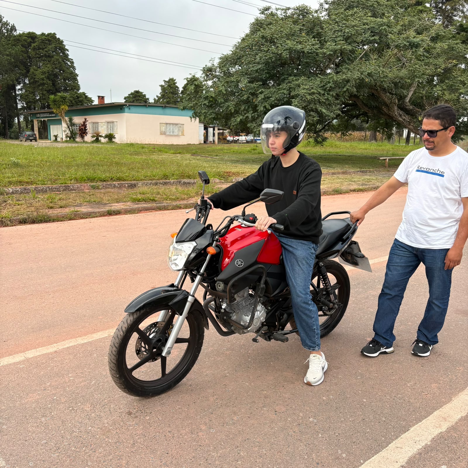 Aluno aprendendo a pilotar moto com instrutor